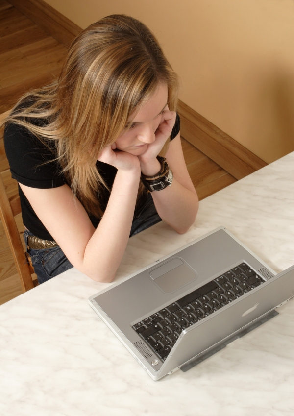 Young girl working on a laptop computer, seen from above