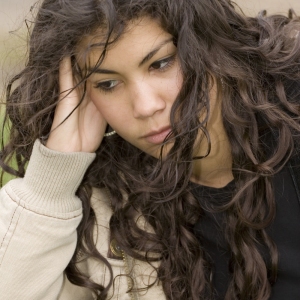 A teenage mixed race girl looking very fed up and depressed