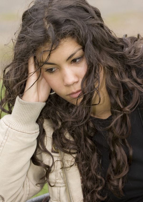 A teenage mixed race girl looking very fed up and depressed