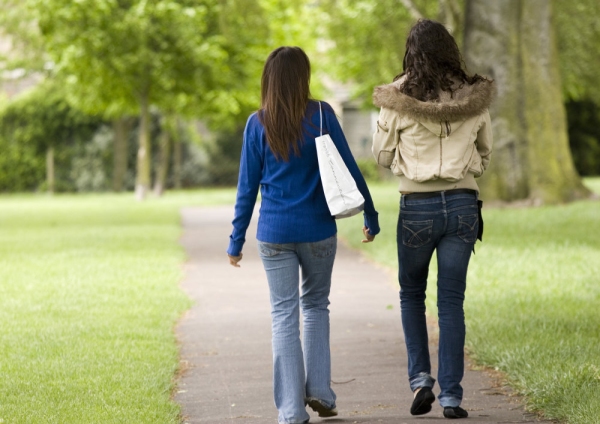 Two girls walking and talking in the park