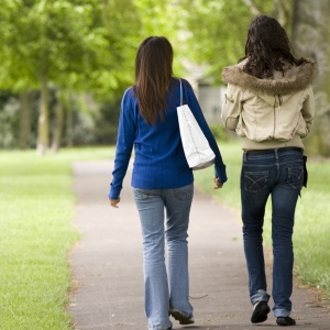 Two girls walking and talking in the park