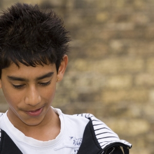 Mixed race teenage boy looking at the ground in an urban setting