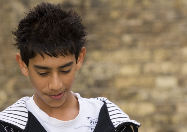 Mixed race teenage boy looking at the ground in an urban setting