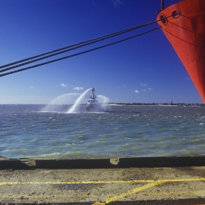 A fire boat testing hoses and equipment in the harbour