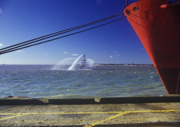 A fire boat testing hoses and equipment in the harbour