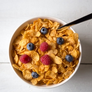 Cornflakes in a bowl with milk and fruits