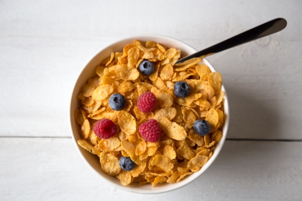 Cornflakes in a bowl with milk and fruits