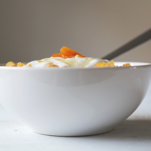 Cornflakes in a bowl with yogurt and honey.