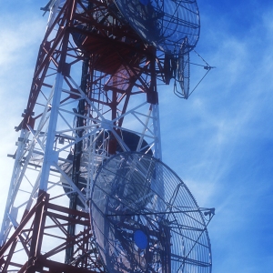 A communications mast silhouetted against a blue sky