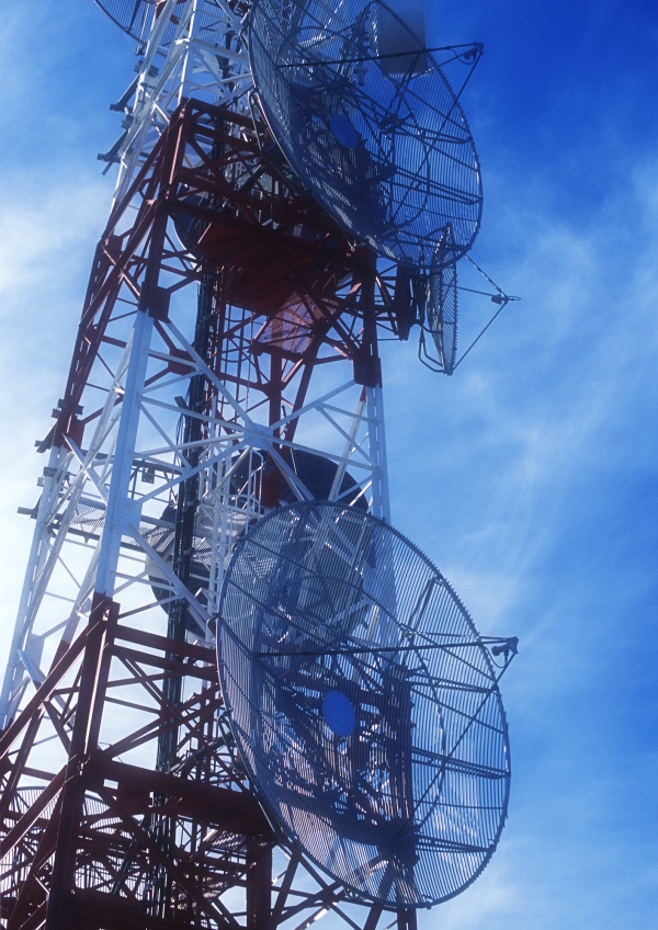 A communications mast silhouetted against a blue sky