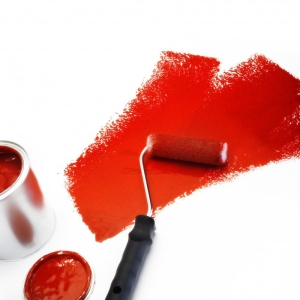 Red paint roller with tin of paint