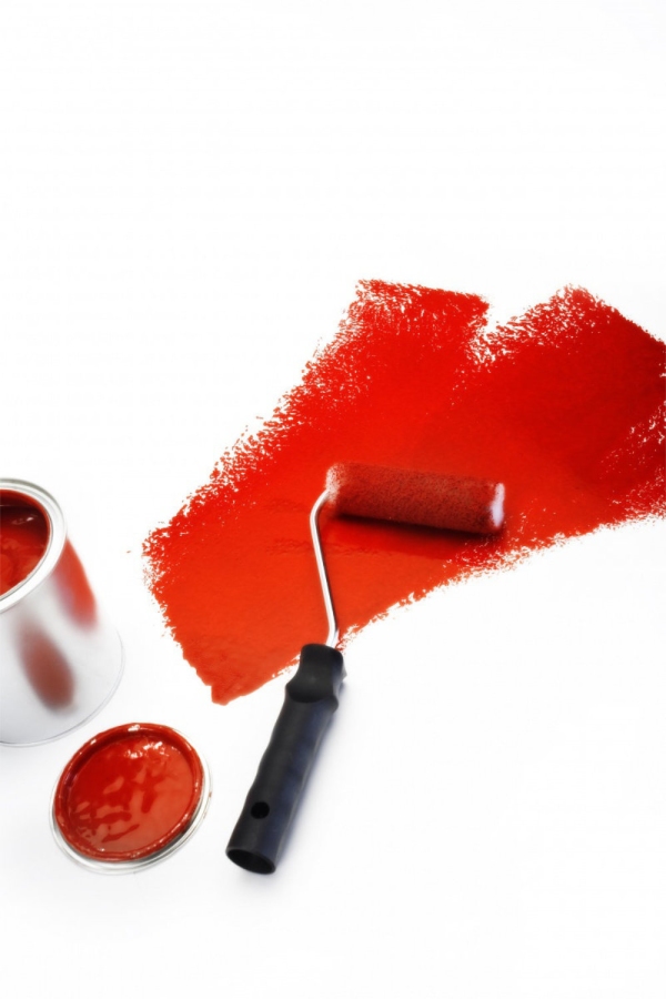 Red paint roller with tin of paint