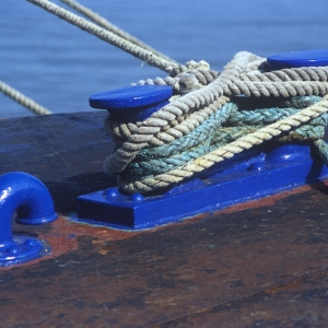 Blue capstans with thick moring ropes on the dockside