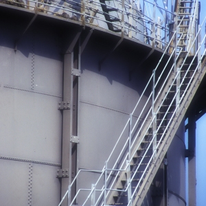 A close up of an oil or chemical storage tank in a tank farm at a container port