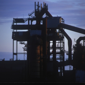 A dark silhouette of industrial equipment in a cement works or sand and gravel pit