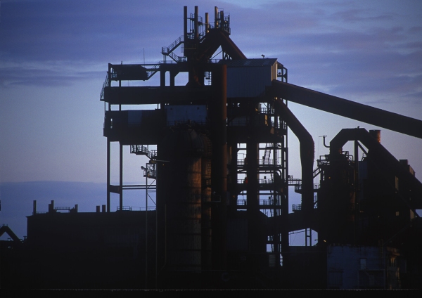 A dark silhouette of industrial equipment in a cement works or sand and gravel pit