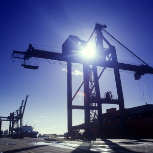 Dockside cranes silhouetted against the sun