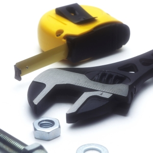 An adjustable spanner with nuts, bolts and tape measure