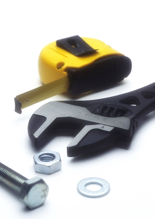 An adjustable spanner with nuts, bolts and tape measure