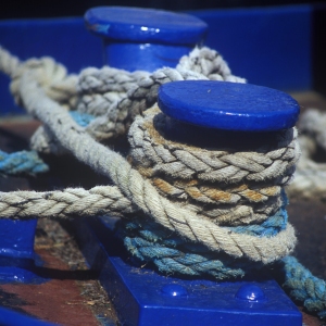 Bue capstans on the dockside with thick mooring ropes