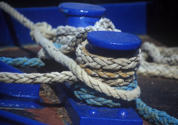 Bue capstans on the dockside with thick mooring ropes