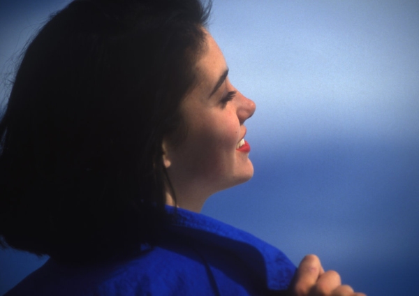 Young woman smiling against a blue sky