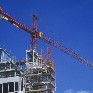 Construction cranes on a large building site with very blue sky