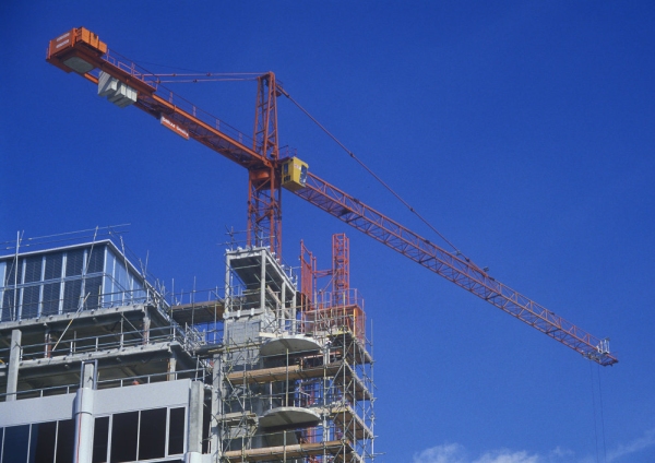 Construction cranes on a large building site with very blue sky