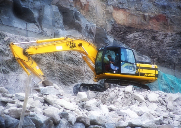 A large 360 digger breaking down a rocky clifftop to build a road