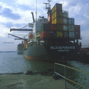 A large container ship unloading at the dockside