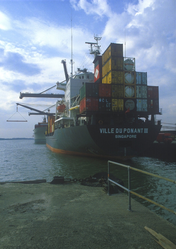 A large container ship unloading at the dockside