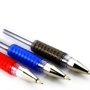 A close up macro view of three different coloured ballpoint pens