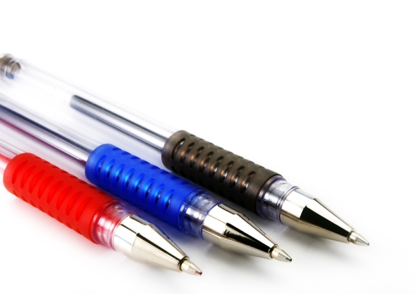 A close up macro view of three different coloured ballpoint pens