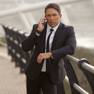 A burly looking security man or business man talking on the phone