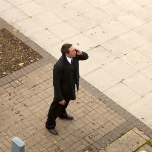 A security guard on the mobile and looking upwards