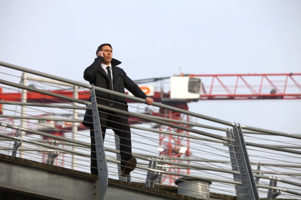 Security guard on a building site with a large crane in the background