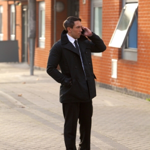 A security officer or businessman checking out an urban area and talking on the phone