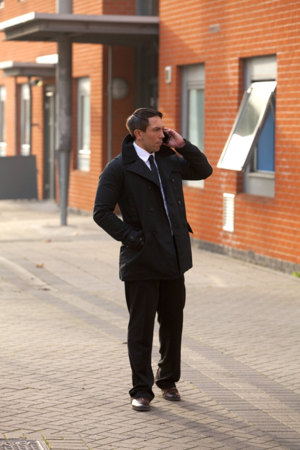 A security officer or businessman checking out an urban area and talking on the phone