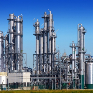 A chemical or gas refinery with a clear blue sky in the background