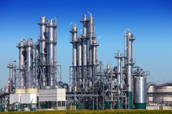 A chemical or gas refinery with a clear blue sky in the background