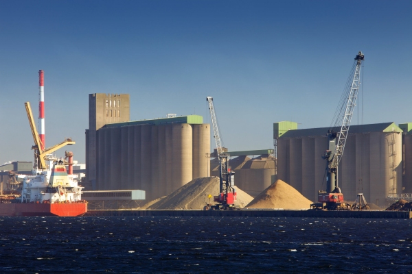 A ship loading or unloading at a heavy industry dock area