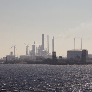 An industrial area including windmills, refineries and storage tanks