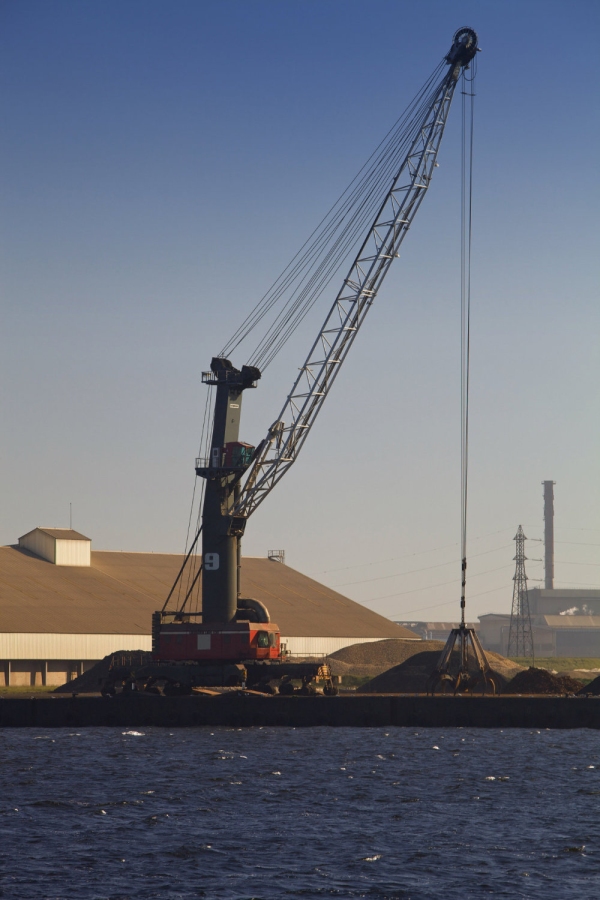 A dockside crane in a heavily industrialised dockland area