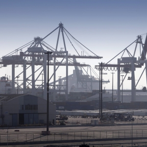 Dockside cranes with a container ship unloading in the background