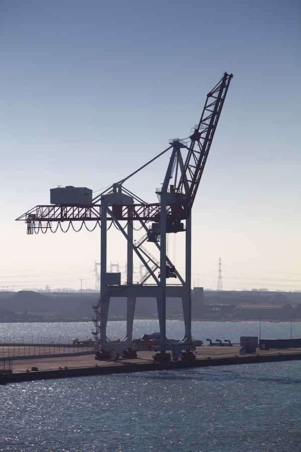 A single dockside crane silhouetted against the late afternoon light