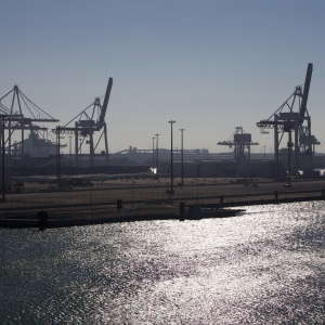 Evening view of an industrial container port with cranes and containers in the background