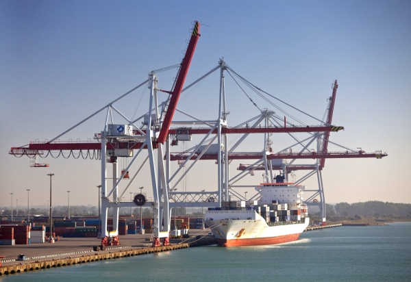 A container ship at port waiting to be unloaded with surrounding