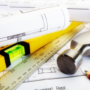 A close up of house building plans and construction tools