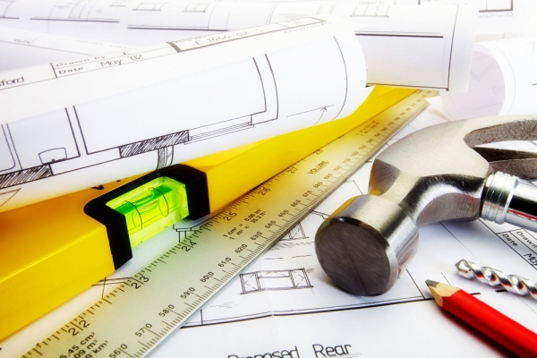 A close up of house building plans and construction tools