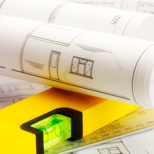 Close up image of plans for a house with ruler and spirit level